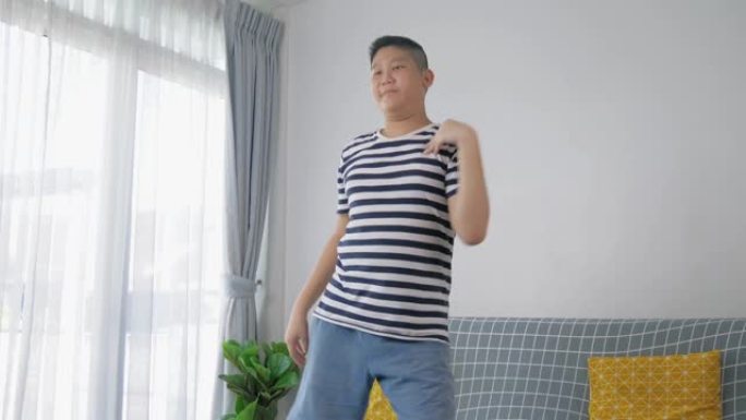 快乐的亚洲青春期男孩跳舞是为了在家锻炼，生活方式的概念。