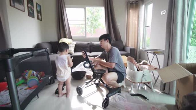 亚洲爸爸在家中客厅安装新婴儿推车