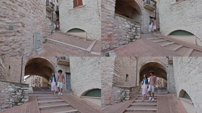 浪漫的夫妇步行参观阿西西的乡村小镇。侧面跟随。翁布里亚的朋友意大利之旅。4k慢动作