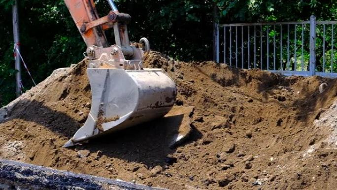 挖掘机将土壤放入沟渠中。