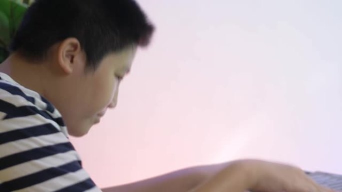 快乐的亚洲男孩玩电动键盘与家人在家聚会，生活方式理念。