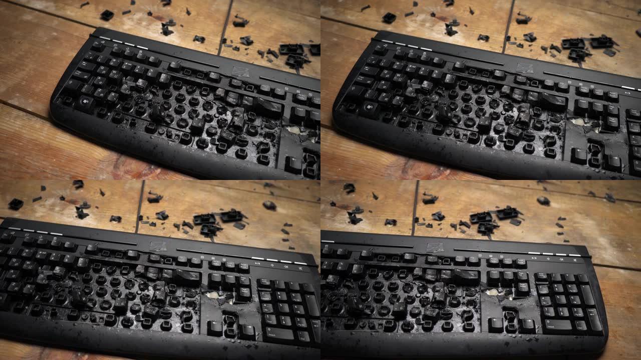 电脑桌上的键盘坏了。愤怒的男子用锤子砸键盘