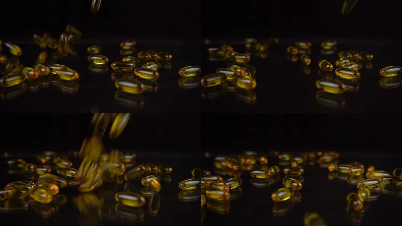 黑色镜子背景下落下的欧米茄3鱼油胶囊的慢动作拍摄。凝胶壳中的金色维生素
