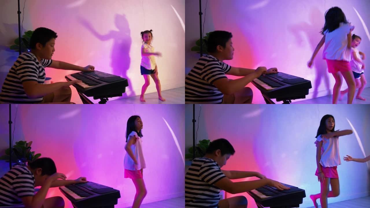 快乐的亚洲孩子在家用发光二极管背景跳舞，在家聚会。