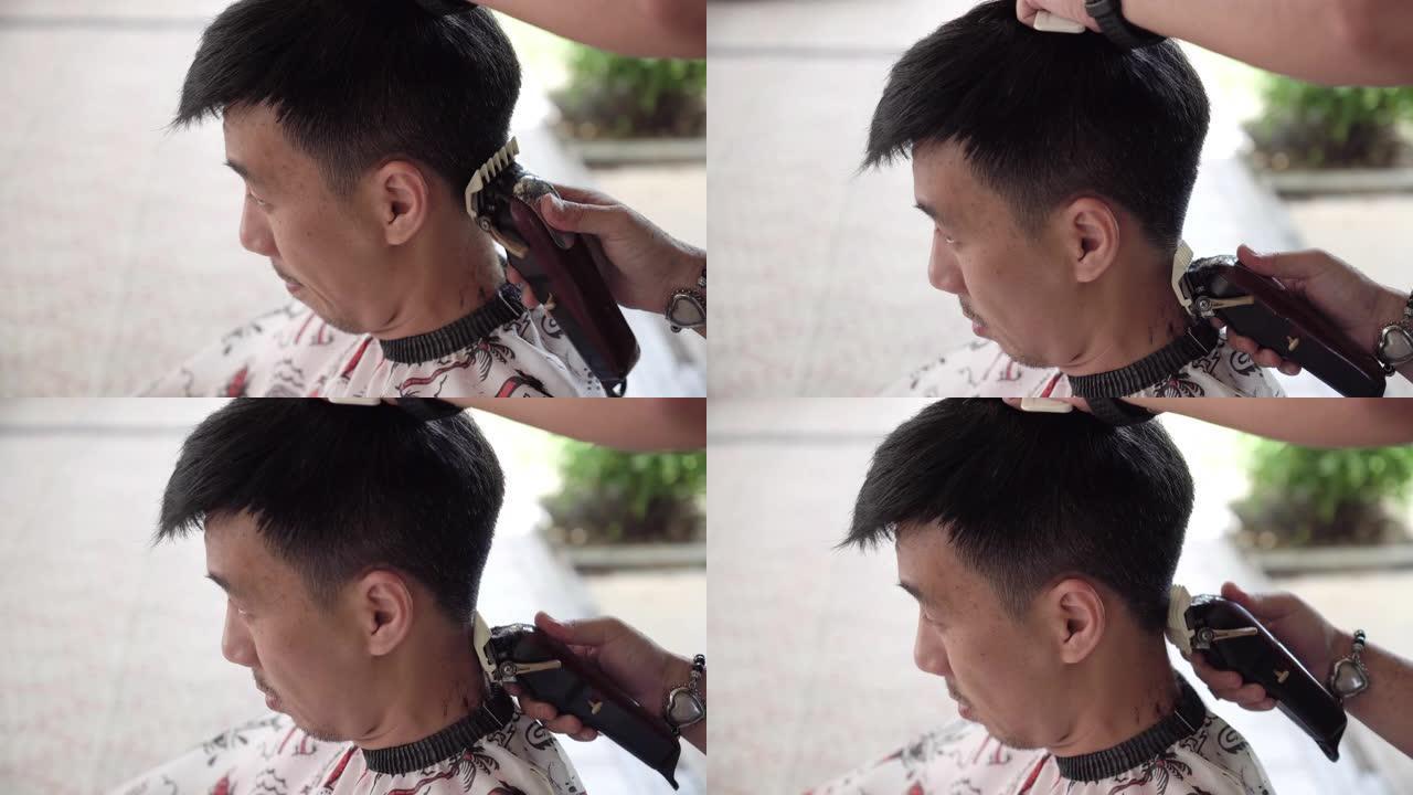 亚洲男子在家被剪发剪发的侧视图。