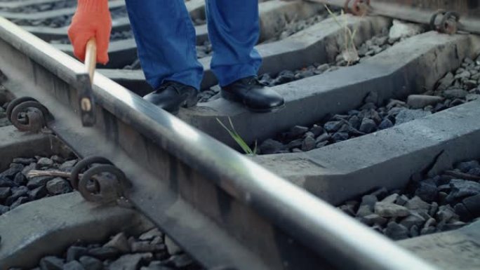 铁路工人的手的低视野用锤子检查铁路的适用性