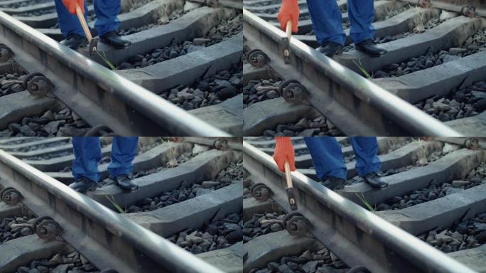 铁路工人的手的低视野用锤子检查铁路的适用性