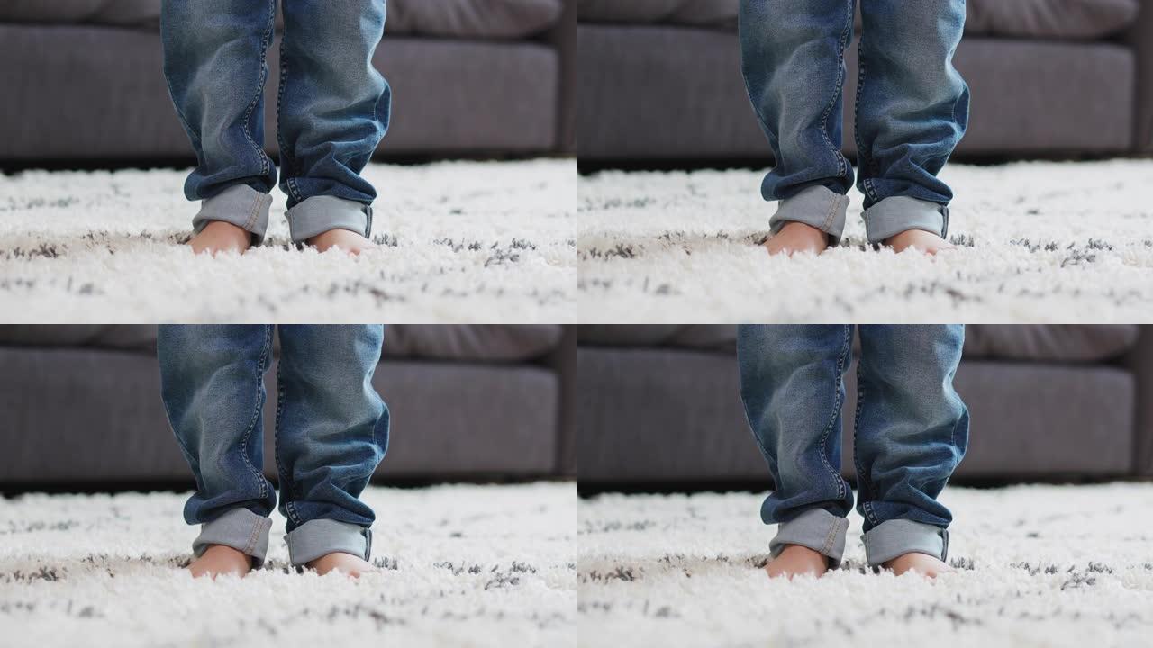 一个小孩穿着一条太大的牛仔裤走路的特写镜头