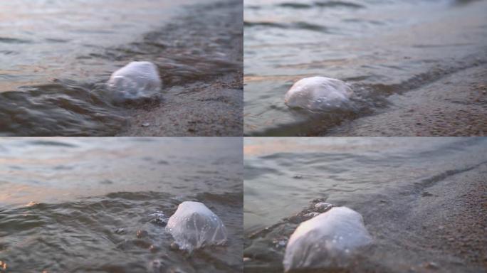 塑料袋漂浮在海水中，在沙质底部被波浪冲刷，靠近。自然破坏，全球环境污染问题。对真正的消费生态的需求
