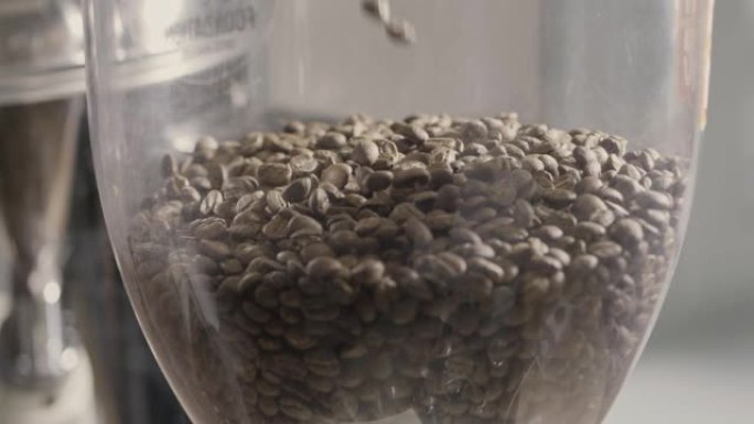 芬芳的烘焙咖啡豆落入咖啡研磨机。慢动作，全高清视频，240fps，1080p.