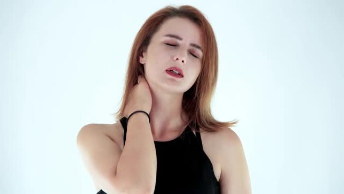 疲倦的年轻女子的肖像颈痛和按摩脖子孤立在白色背景上。工作室拍摄。看起来疲惫、过度劳累的概念。