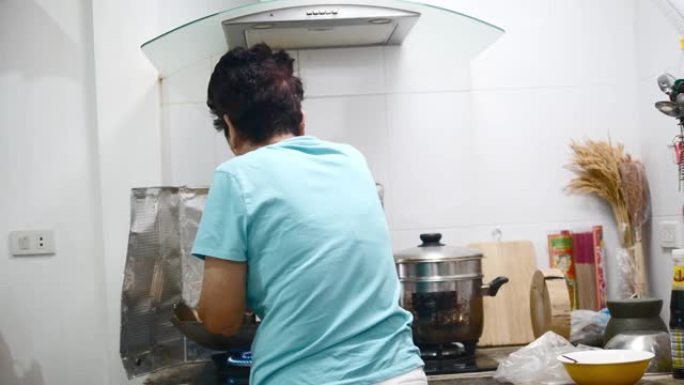 亚洲高级女性在厨房为家庭做饭，生活方式理念。