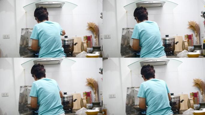 亚洲高级女性在厨房为家庭做饭，生活方式理念。