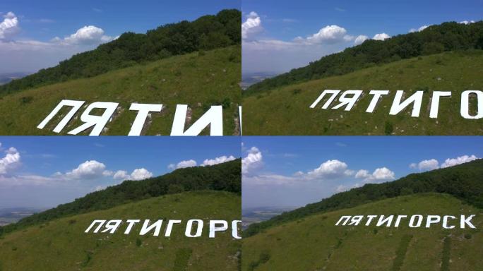 绿色马舒克山上白色大字pyatimorsk的鸟瞰图。
