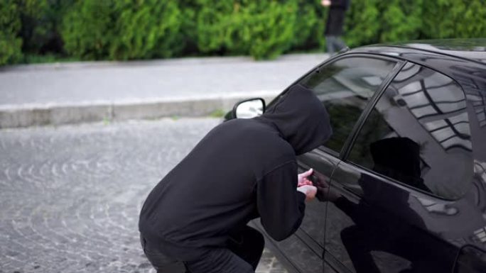 偷车贼偷车破门犯罪工作窃贼劫持偷车贼黑色巴拉克拉瓦帽衫试图闯入汽车螺丝刀