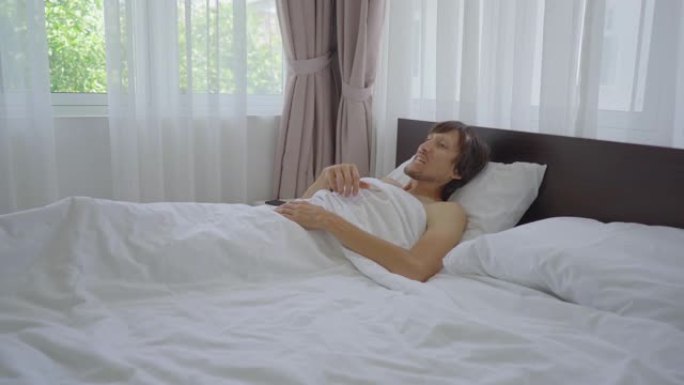 一个躺在床上的年轻人在睡觉前戴上牙齿防护装置。防磨牙保护器概念