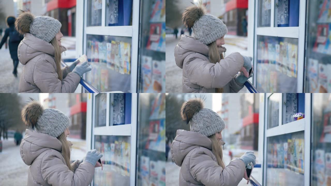 微笑的少女在售货亭买糖果的侧视图