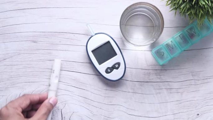 将糖尿病测量套件放在桌子上的人的俯视图