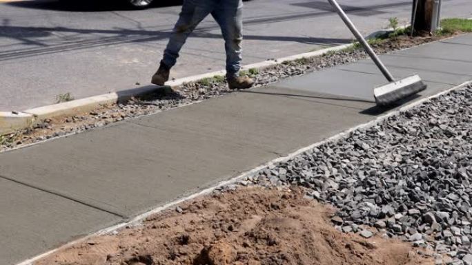 工人在sidewal期间在新水泥上完成光滑的混凝土表面