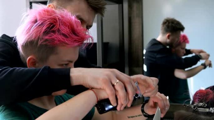 粉红色头发的女人正在训练制作机器男性理发