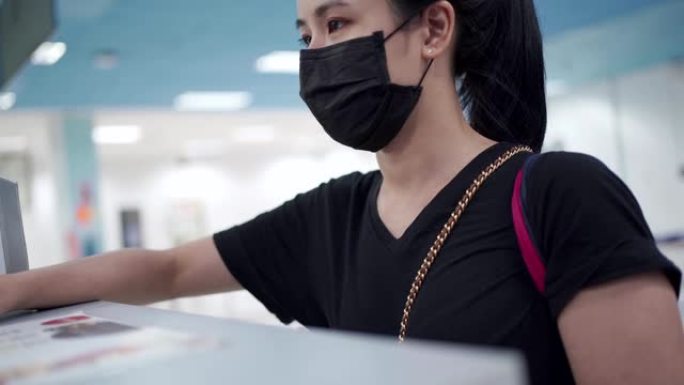 年轻的亚洲妇女交旅行证件，身份证，护照到值机柜台登记簿，订票登机牌，新型冠状病毒肺炎新的正常旅行保持