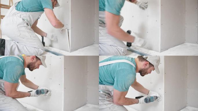 工人安装一小片干墙，首先剃光边缘，然后将其钻到墙上