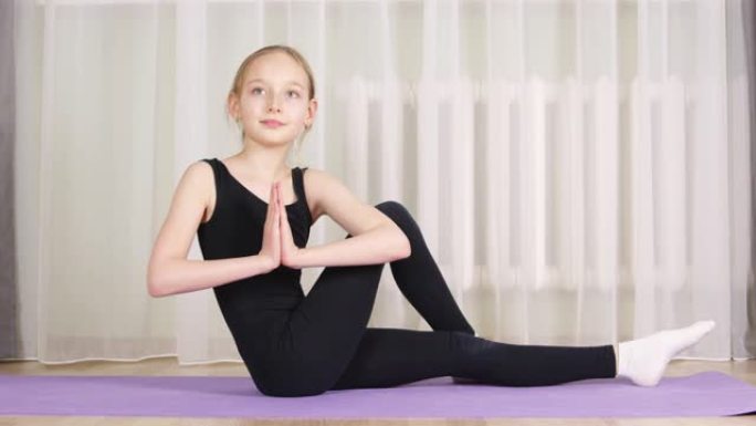 瑜伽女孩在家庭训练中练习Ardha Matsyendrasana。健身女孩在室内健身房训练瑜伽体式。