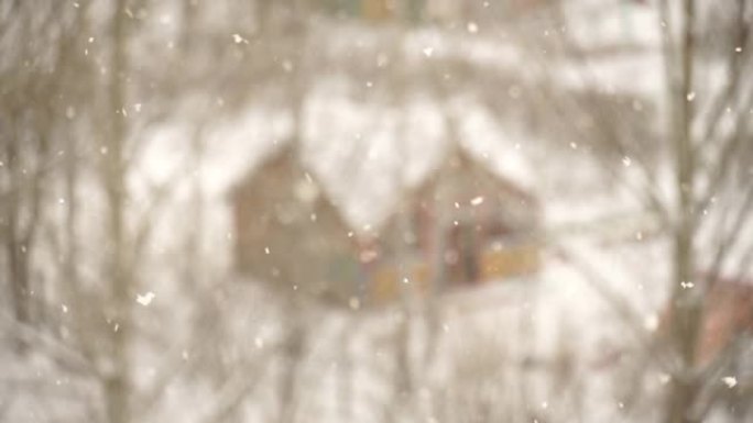 冬季降雪。蓬松的雪花飞舞，随风旋转。雪中可爱的木屋。圣诞节散焦抽象背景。新年假期。冬季大销售和礼品广