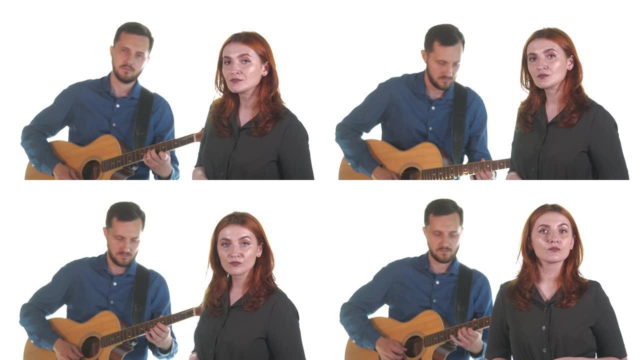 年轻音乐家的二重唱。男人弹吉他。女人在唱歌。孤立。白色背景