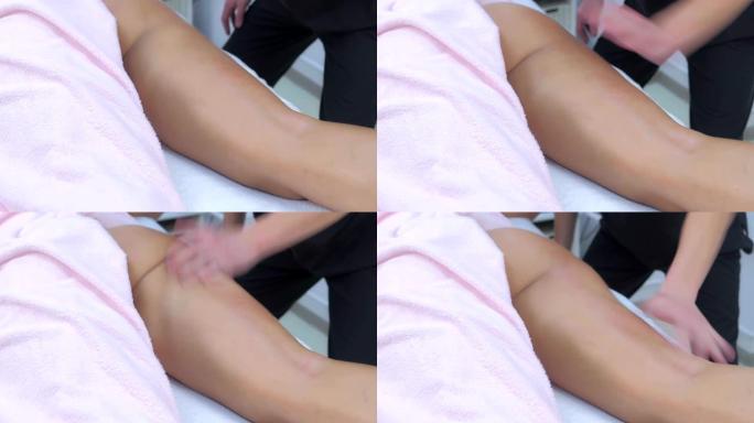 男性医生在诊所为女性擦腿做雕塑身体提升按摩。