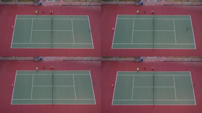 女孩和男孩正在打网球，他们的网球教练正在展示正手高清视频无人机视图