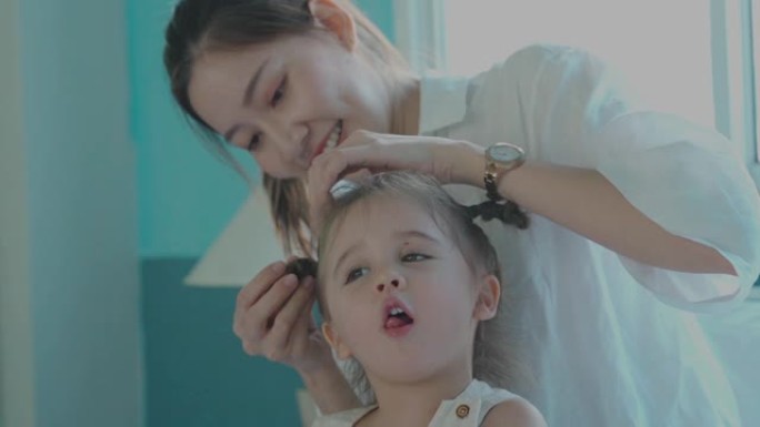 妈妈整理女儿的头发，在家上学的概念