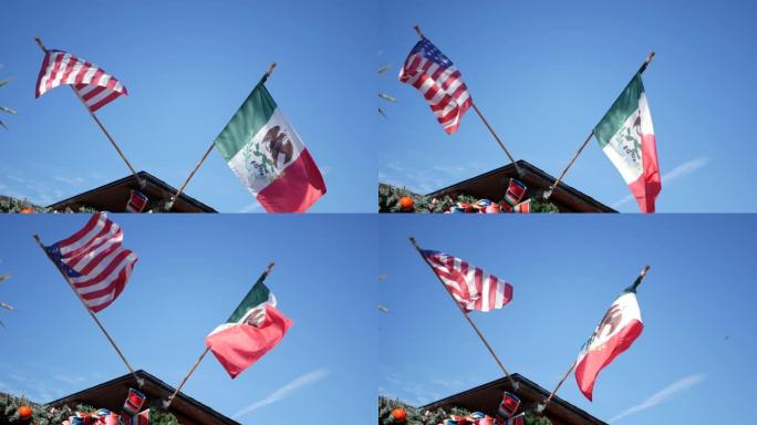 墨西哥三色旗和迎风飘扬的美国国旗。墨西哥和美国的两个国家标志在天空的映衬下，美国加州圣地亚哥。边界、
