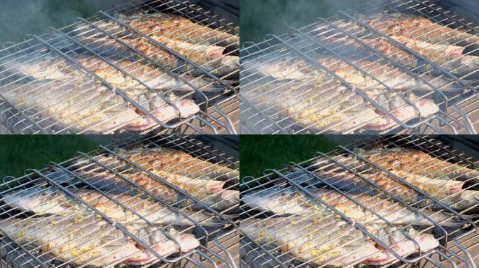 用木炭烤的鲈鱼或石斑鱼。在烧烤烤架板上用芳香香料烹饪海鱼的特写镜头