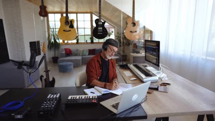 高级作曲家在他的家庭办公室工作室创作他的新歌