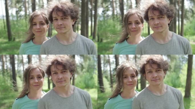年轻夫妇站在户外阳光明媚的森林中的肖像。轨道摄像机