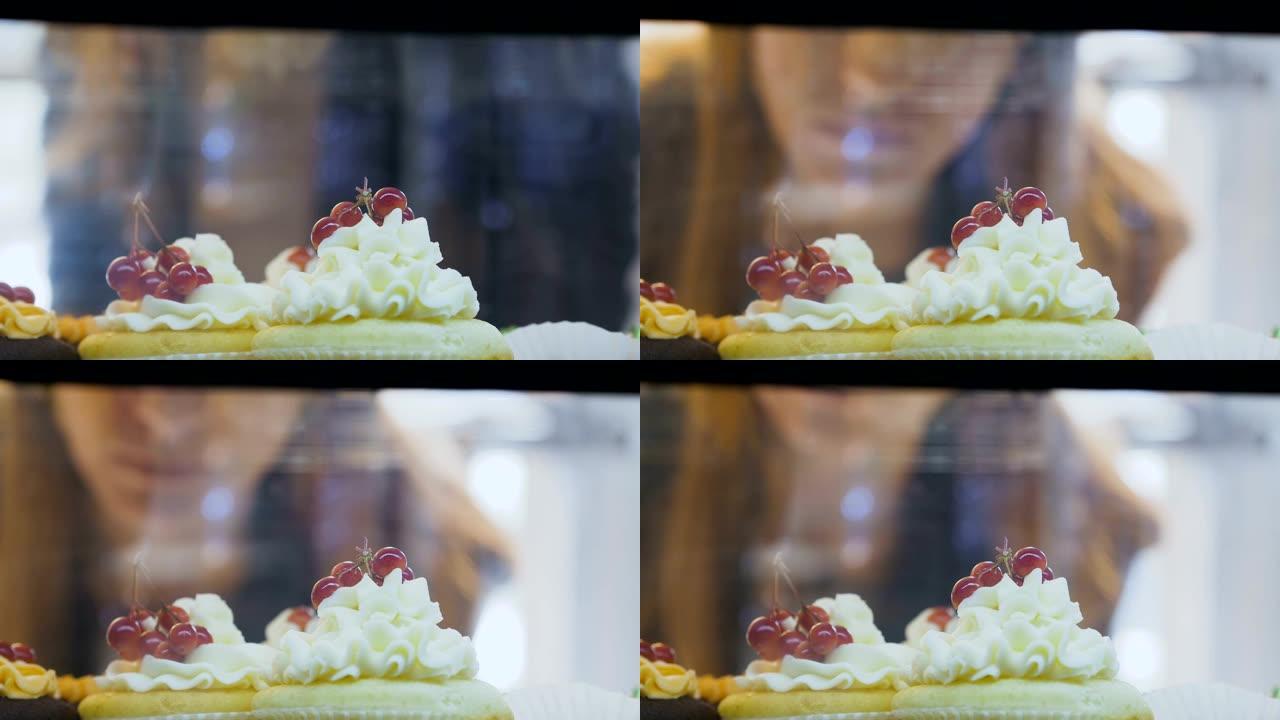 在蛋糕店的窗盒上整理的带有奶油和浆果的甜纸杯蛋糕的特写镜头