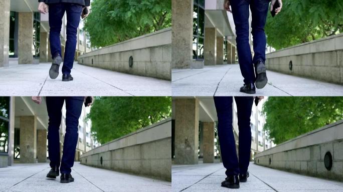 男性腿穿过人行道的后视图