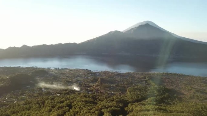 全景无人机从印度尼西亚巴厘岛的巴图尔山上空拍摄。周围有很多山。黄金早晨。360度视图。山谷中的小村庄