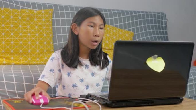 新型冠状病毒肺炎期间使用笔记本电脑在家上学的亚洲女孩。