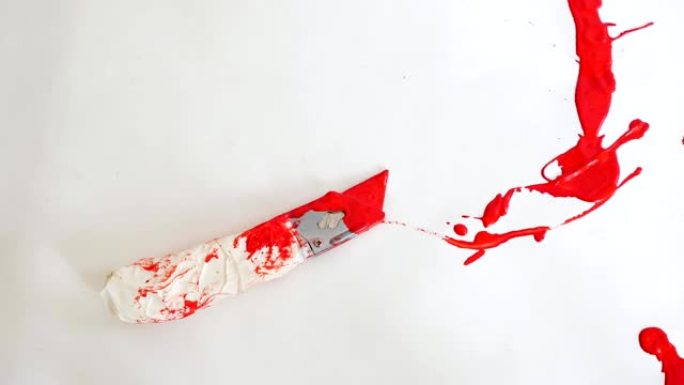 盒子切割机位于红色油漆滴中的白色背景上