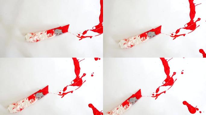 盒子切割机位于红色油漆滴中的白色背景上
