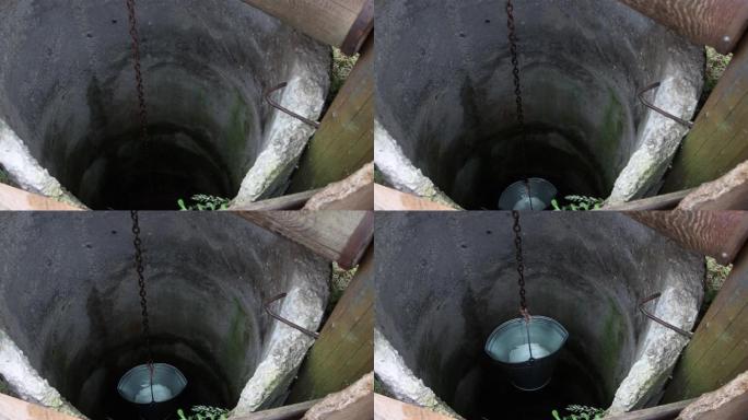一个装满水的水桶从井里慢慢升起。
