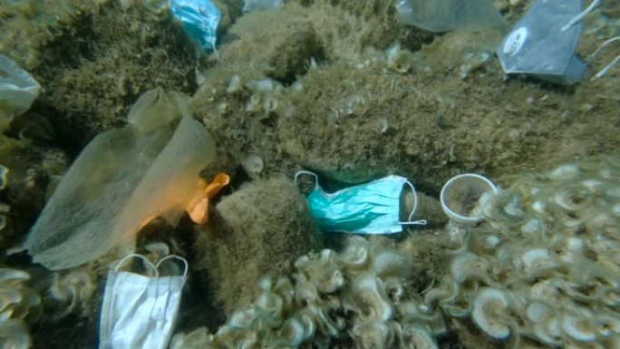 冠状病毒新型冠状病毒肺炎正在造成污染，因为废弃的二手口罩和塑料垃圾一起污染海底。亚得里亚海海底的瓶子