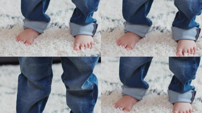 一个小孩穿着一条太大的牛仔裤走路的特写镜头