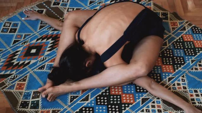 年轻女子在地毯上做瑜伽