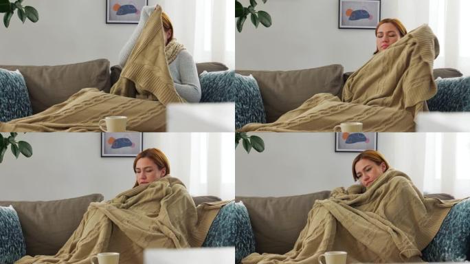 生病的女人在家里用围巾包裹在毯子上