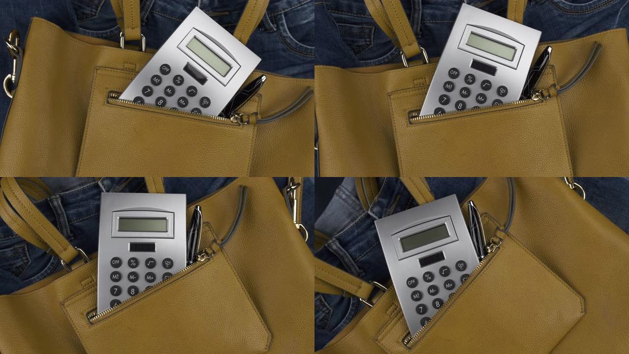 计算器和笔从女人的书包的口袋里伸出来。轮动。