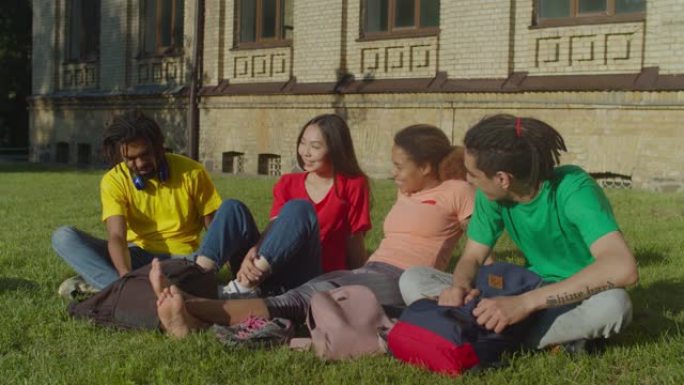 多元化的多民族学生在校园草坪上放松
