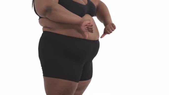 无法辨认的黑人肥胖妇女穿着内衣的背部摇晃她的战利品孤立在白色背景上